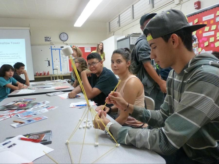 Students hover around a career day presenter and learn about Civic Engineering. Project ARIES has this career day each year, offering students opportunities to learn about possible future career choices. “This is very useful information for me to have and to think about when I apply for a job,” said Ransom Kauwe (10).