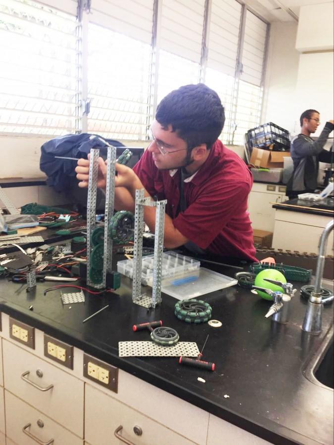 STEM Applications student Jacob Krieger (12) works on one of two robots the class built. The team recently competed in the VEX competition in August, where they designed their robot to pick up and launch a ball into a net on the other side of the field. “When you come in, you are expected to get onto your project and start building,” Krieger said.