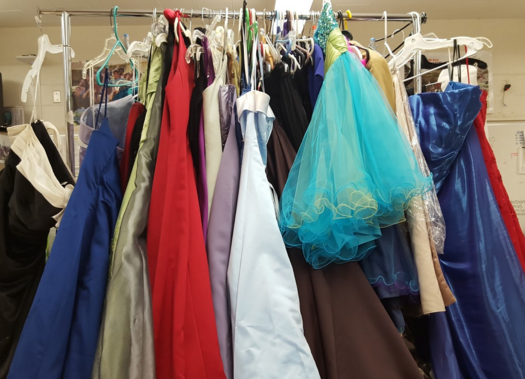 Racks of prom dresses and men's jackets are available to prom goers in room 113 . Attire and accessories are free of charge to students who are unable to pay the costs of prom wear. “Many alumni outgrow the dresses, or will never go to a prom again, or will get another gown,” Student Activities Coordinator John Goto said, “so there are always others who can use it to save their money for other things.”