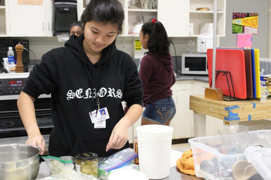 Katherine Kan (12) prepares ingredients for an artichoke dip in her Culinary III course. Project ARIES featured five new courses for next year, one of them being Baking and Pastry. “Students who enjoy baking or have the passion should definitely take this class so they can earn a credit while doing something they love,” Jamie Kahalewai, culinary teacher, said. 