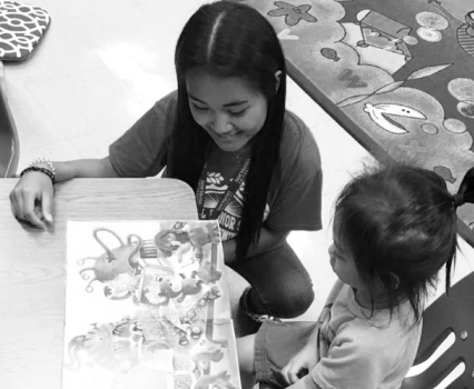 Rashelle Bumanglag (12) reads to a preschooler at Makalapa Elementary. NHS members visited the school multiple times this quarter during TASK and recess to read to students. Photo Submitted by Kristine Namnama