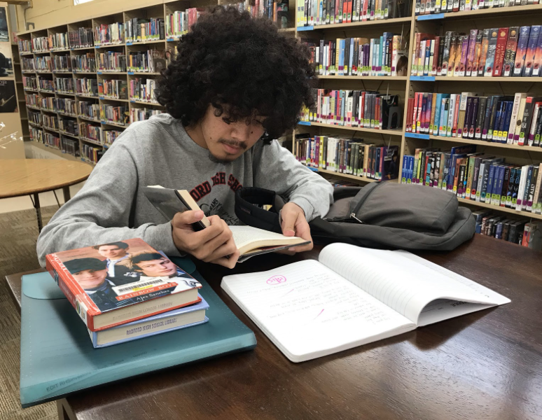 Senior Micah Gallen keeps himself busy with
homework and studies in the library after school. Photo taken by Brandon Bagoyo

