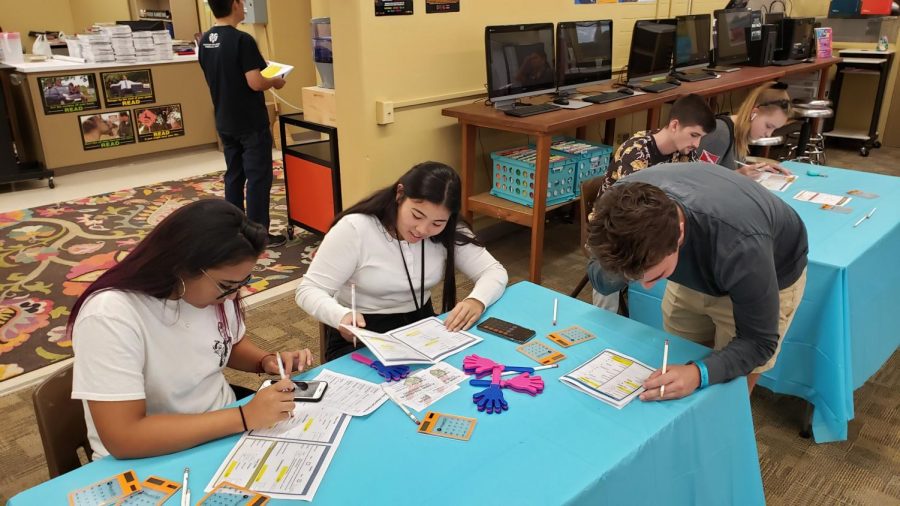 Alyssa Sunday (12) works with her peers to add up daily lifestyle costs.