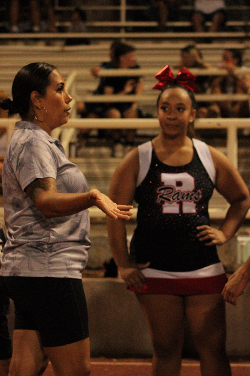 Shyanne Kuwahara (left) speaks to Skylly Paulo (right) and the rest of the team during halftime on the September 12 football game against Nanakuli.